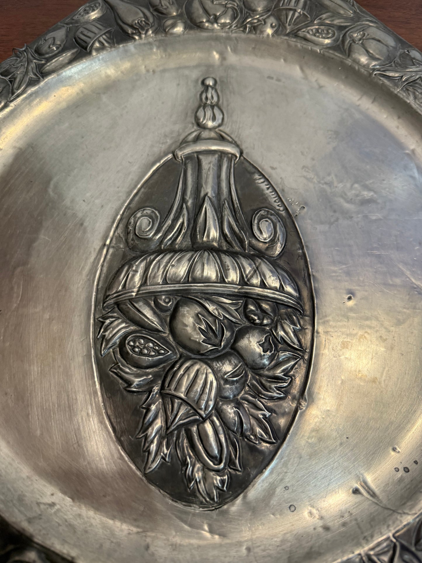 Grande assiette murale en métal repoussé signée Coquerelle – décor corbeille de fruits