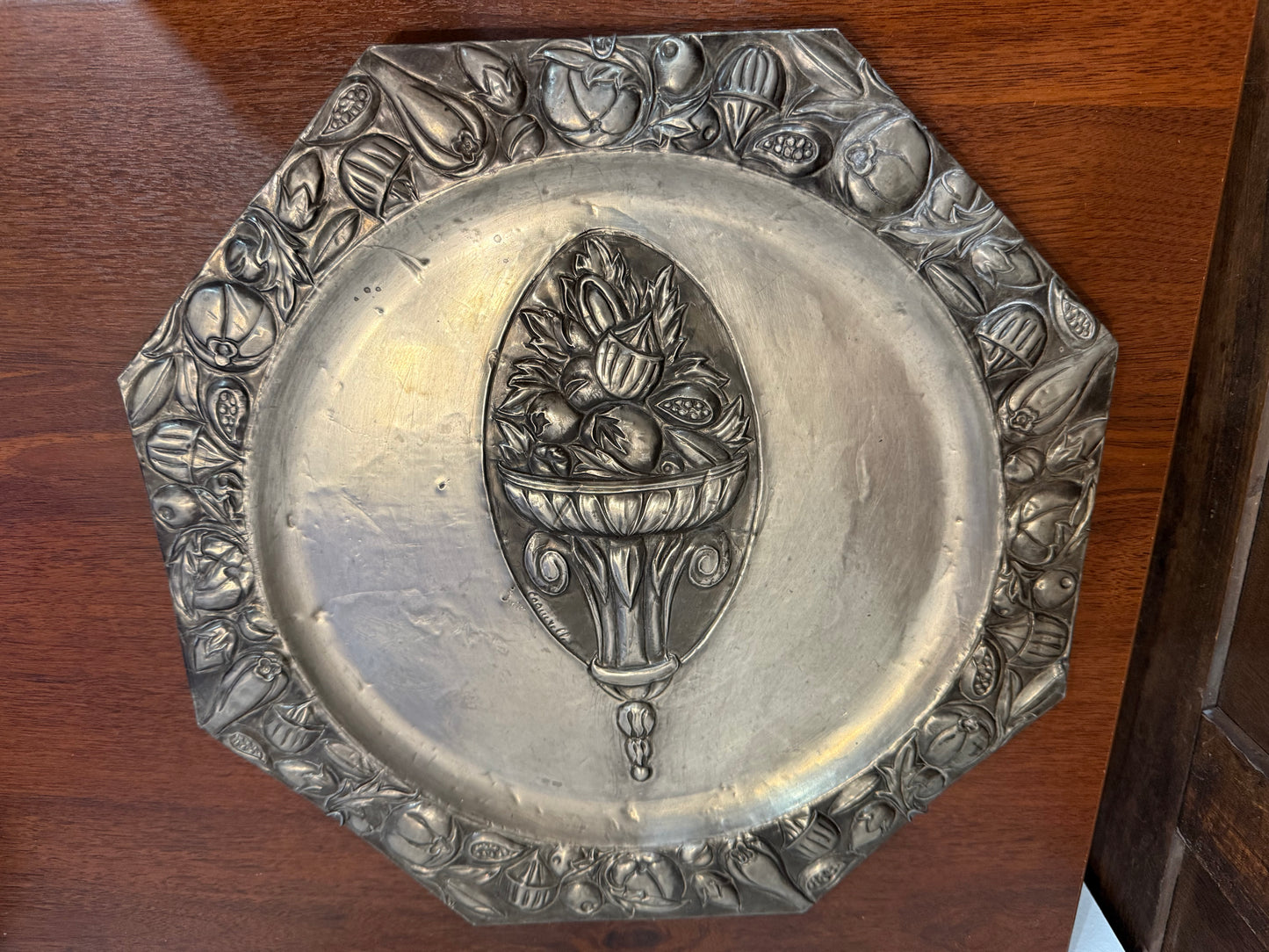 Grande assiette murale en métal repoussé signée Coquerelle – décor corbeille de fruits