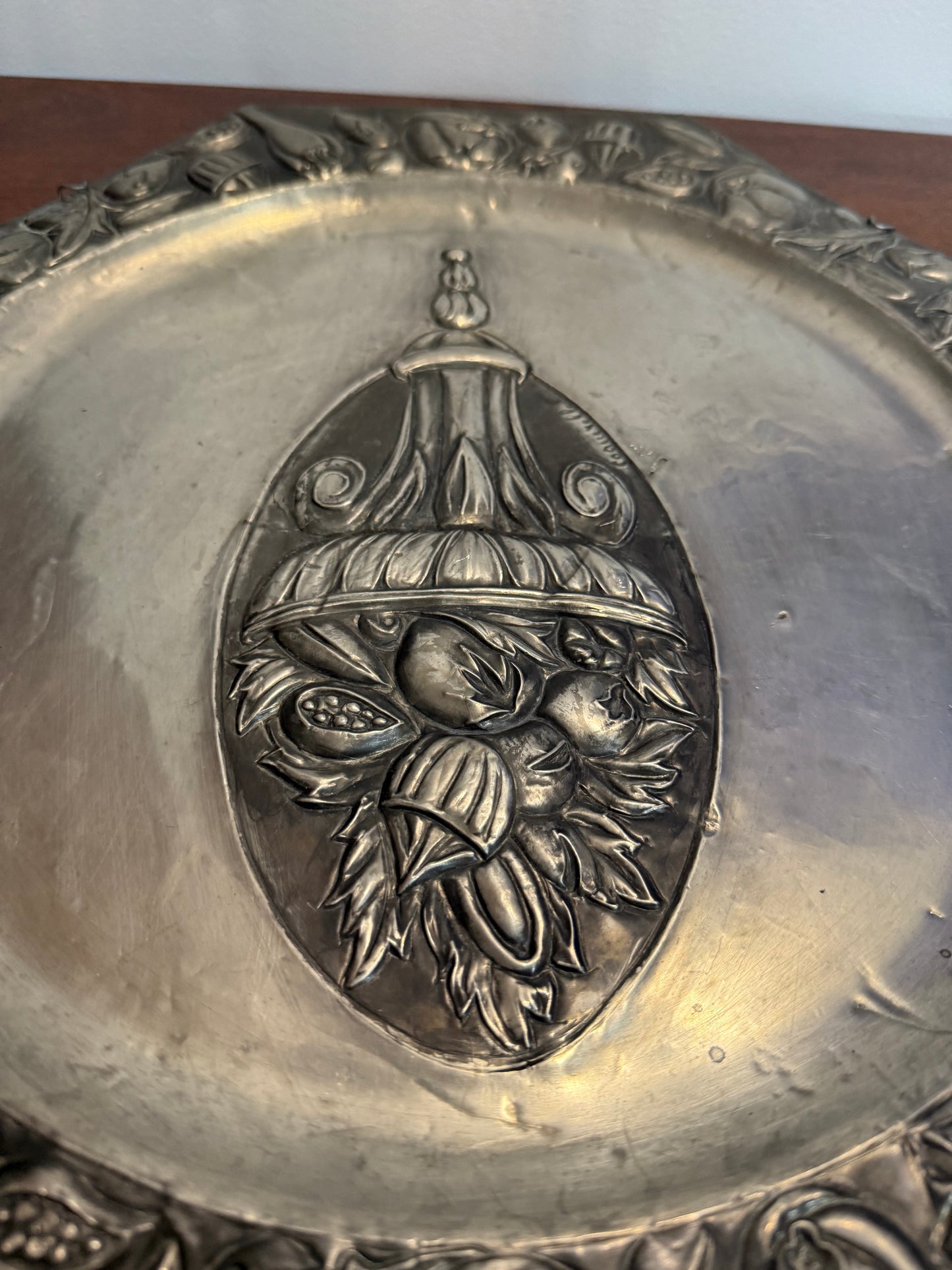 Grande assiette murale en métal repoussé signée Coquerelle – décor corbeille de fruits