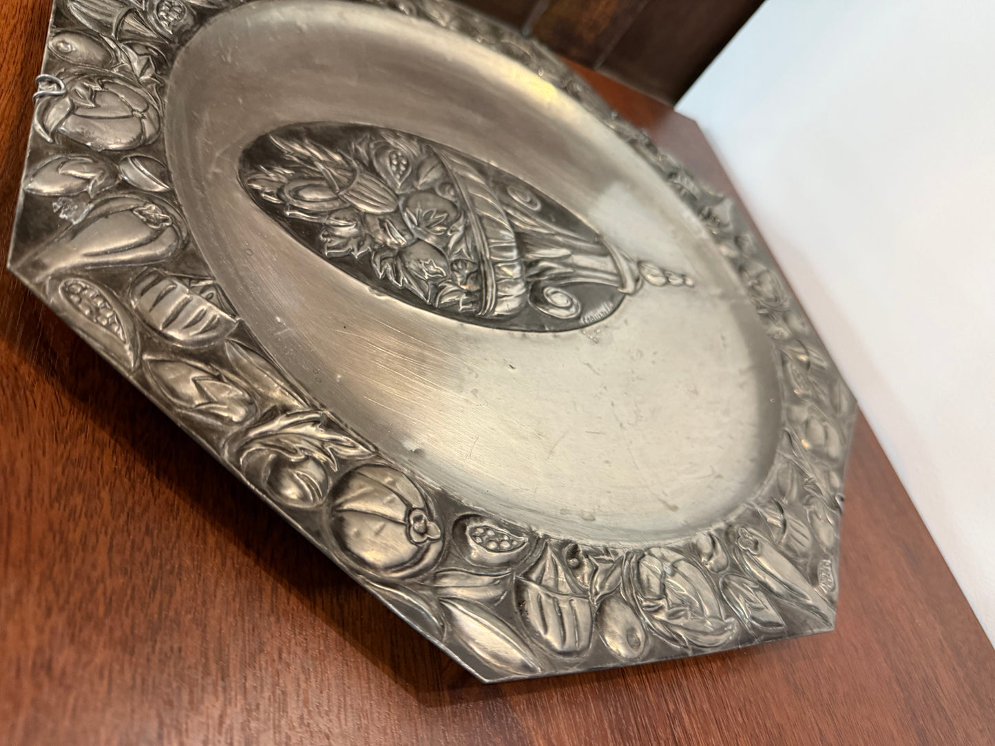 Grande assiette murale en métal repoussé signée Coquerelle – décor corbeille de fruits