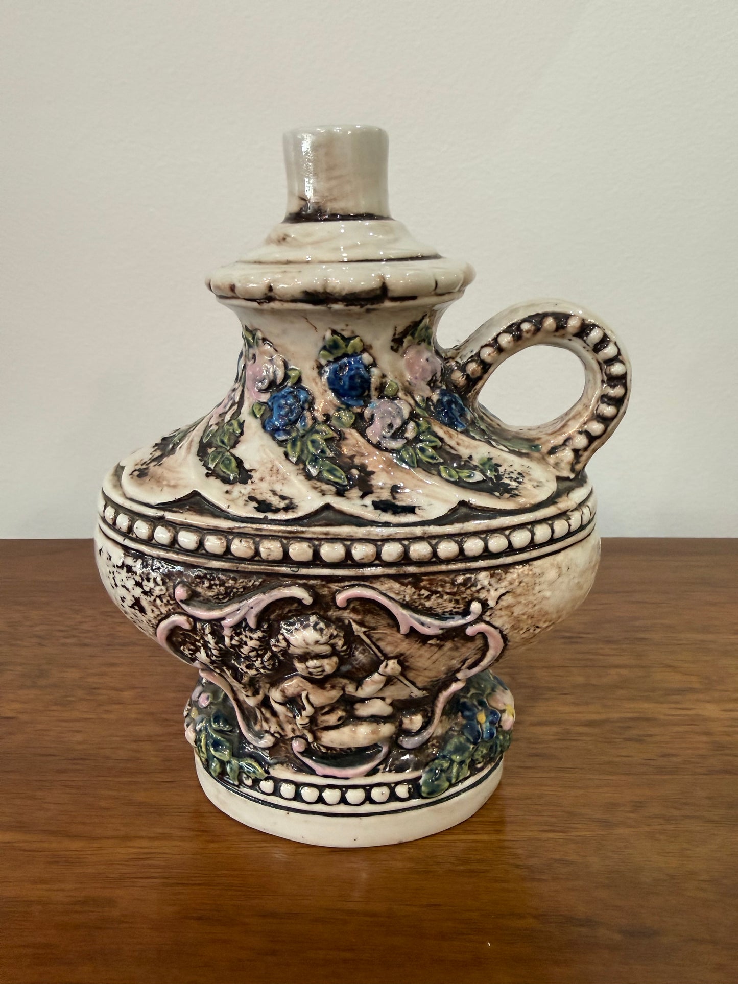 Vase / aiguière en céramique barbotine à décor angelot et fleurs en relief – Cachet sous base – H. 19 cm