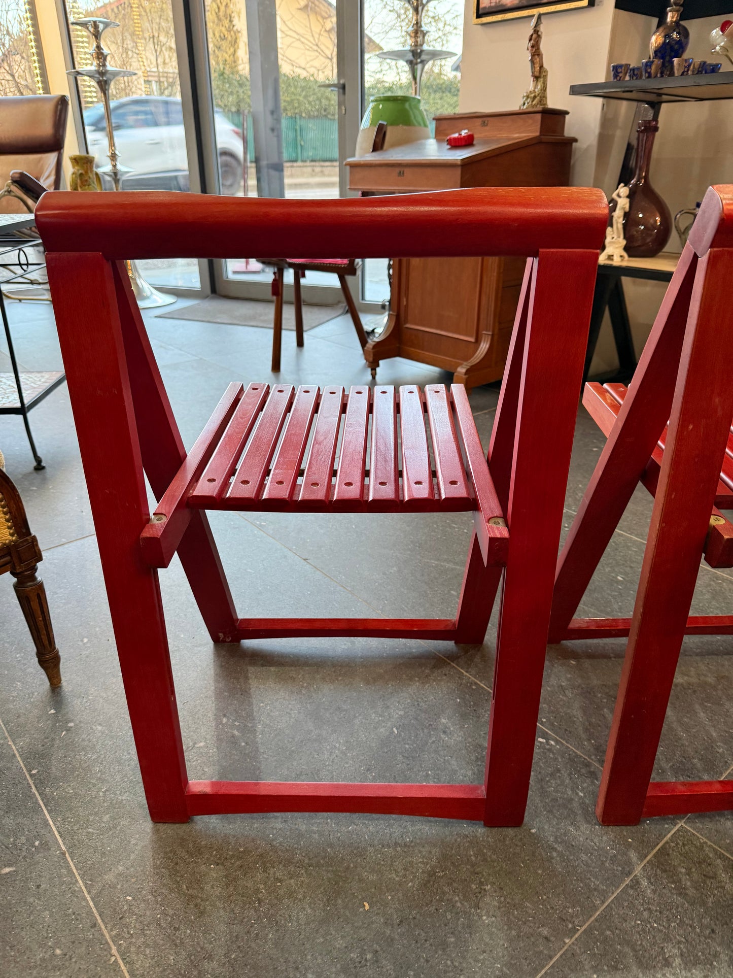 Lot de deux chaises pliantes en bois laqué rouge – Travail artisanal – Années 1980