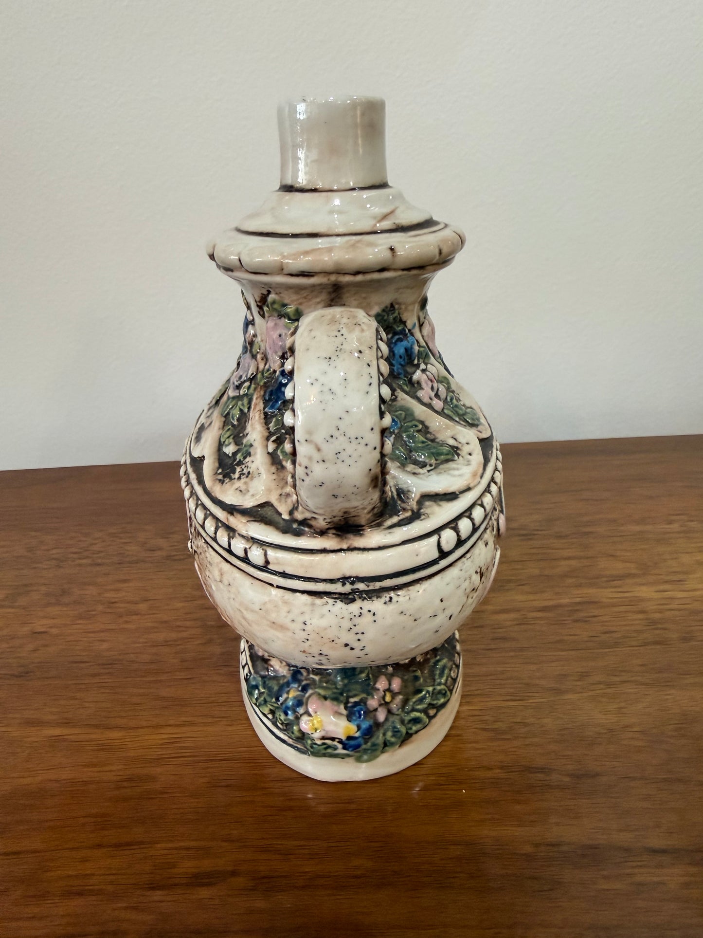 Vase / aiguière en céramique barbotine à décor angelot et fleurs en relief – Cachet sous base – H. 19 cm