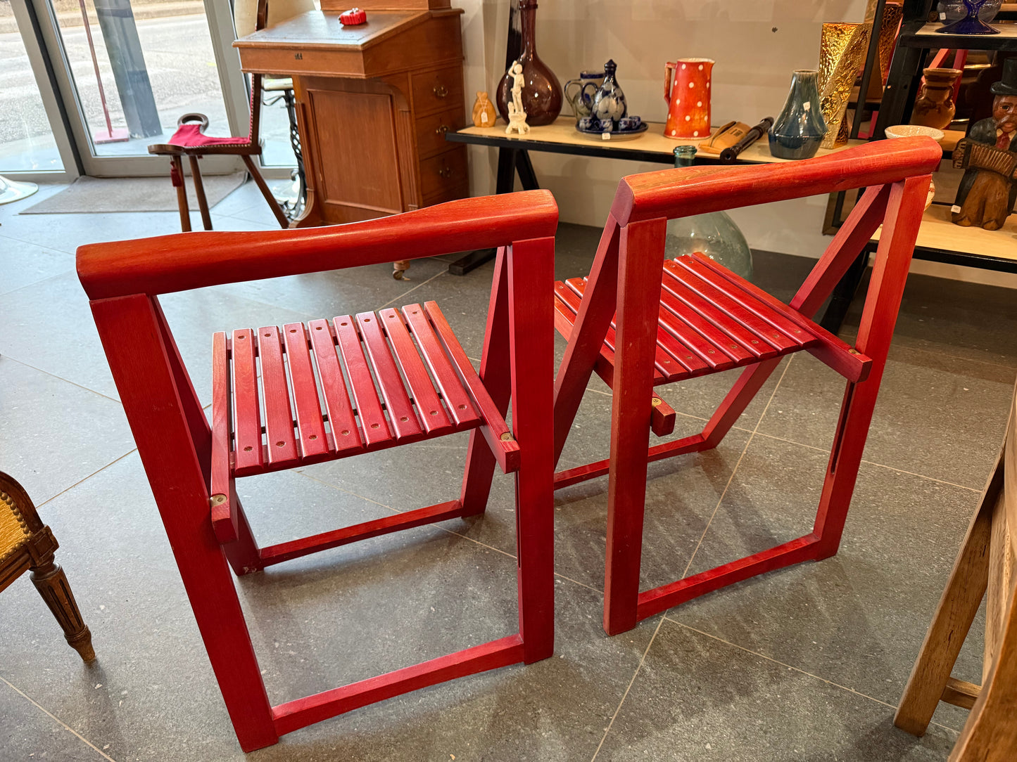 Lot de deux chaises pliantes en bois laqué rouge – Travail artisanal – Années 1980