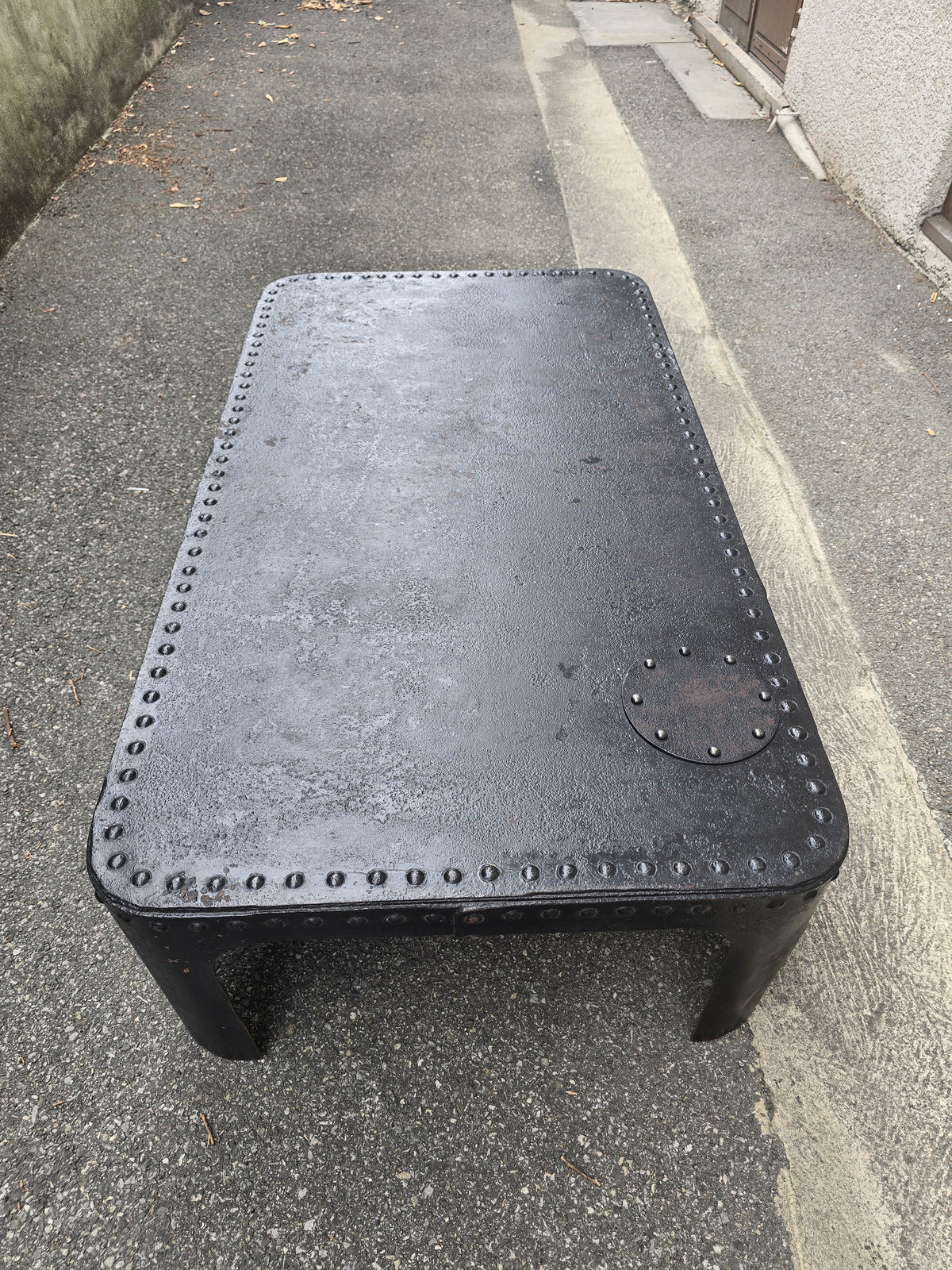 Table basse industrielle en métal riveté vers 1920 – patine noire – 145 × 80 cm