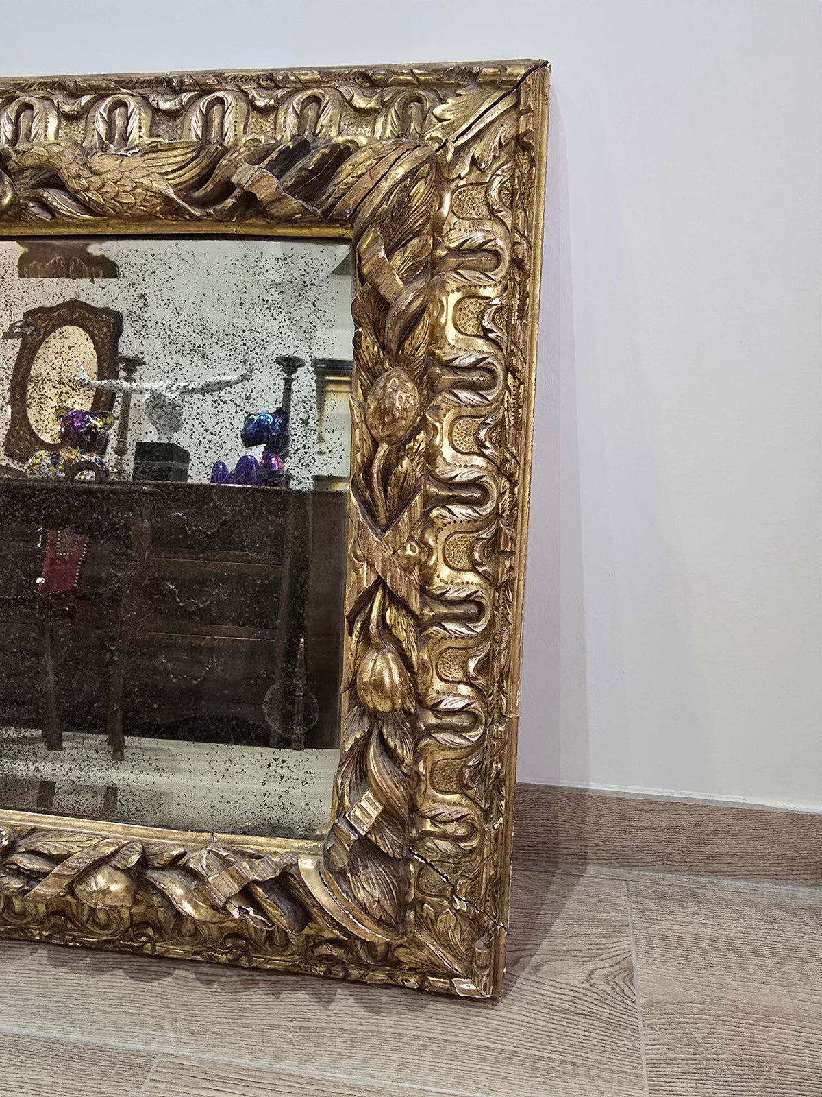 Exceptionnel miroir XVIIIe siècle en bois sculpté doré – décor oiseaux, fruits et angelot – 98 x 68 cm.