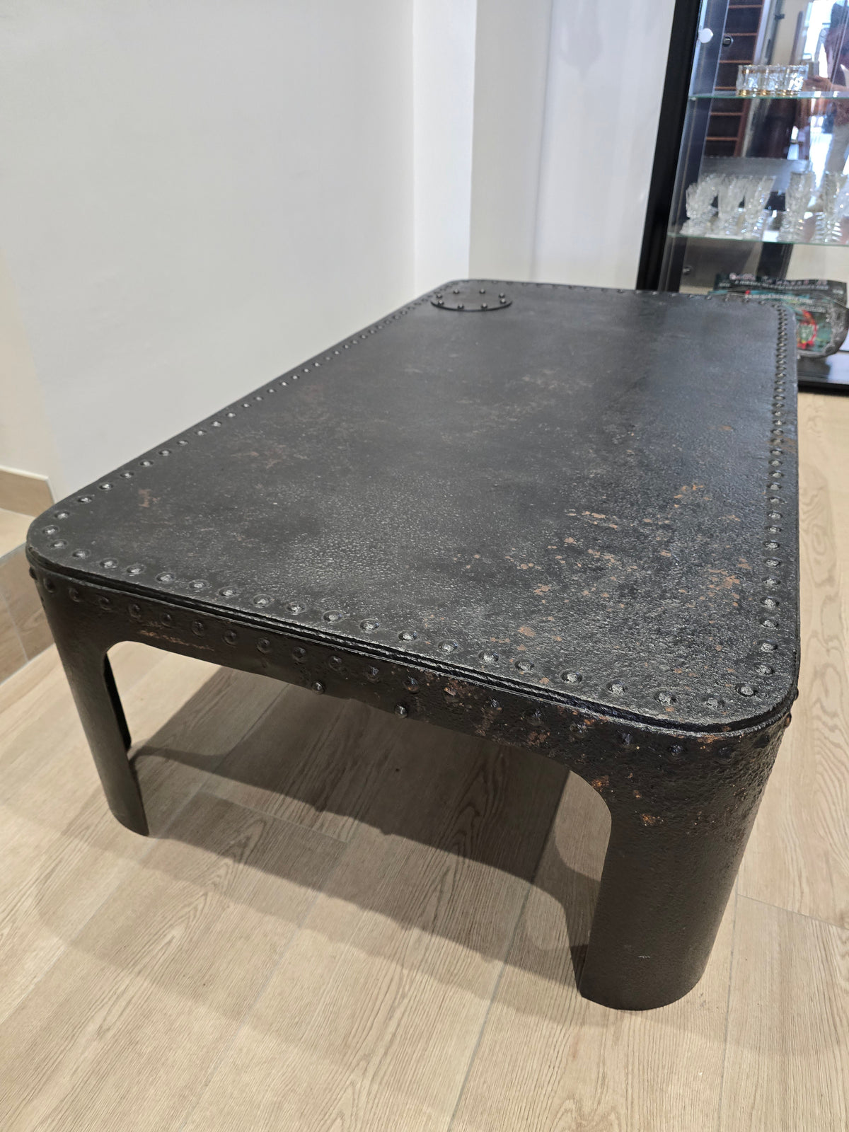 Table basse industrielle en métal riveté vers 1920 – patine noire – 145 × 80 cm