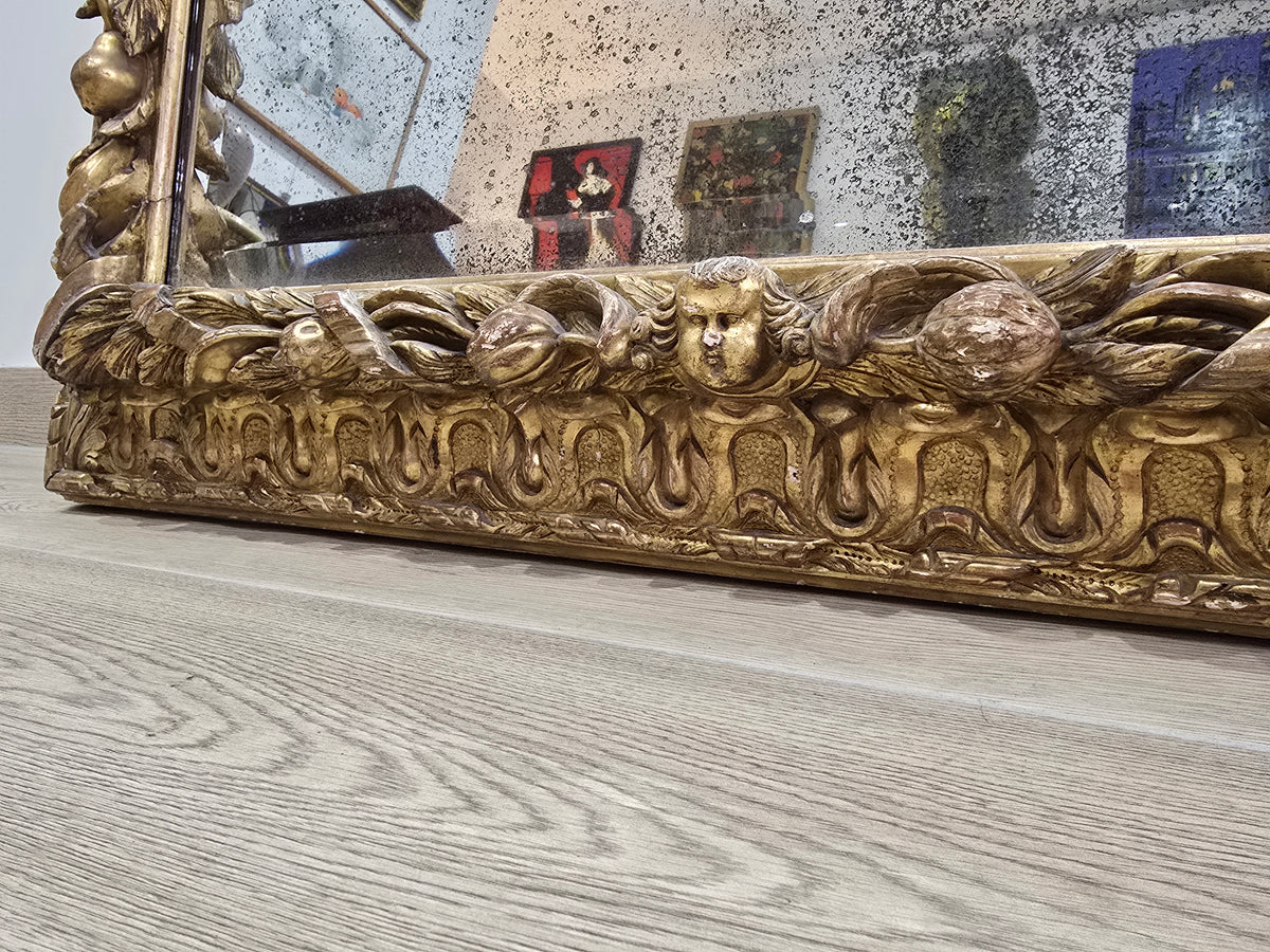Exceptionnel miroir XVIIIe siècle en bois sculpté doré – décor oiseaux, fruits et angelot – 98 x 68 cm.