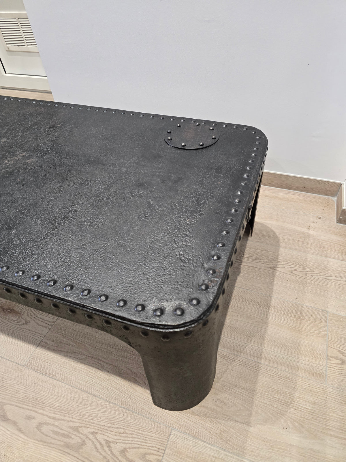 Table basse industrielle en métal riveté vers 1920 – patine noire – 145 × 80 cm