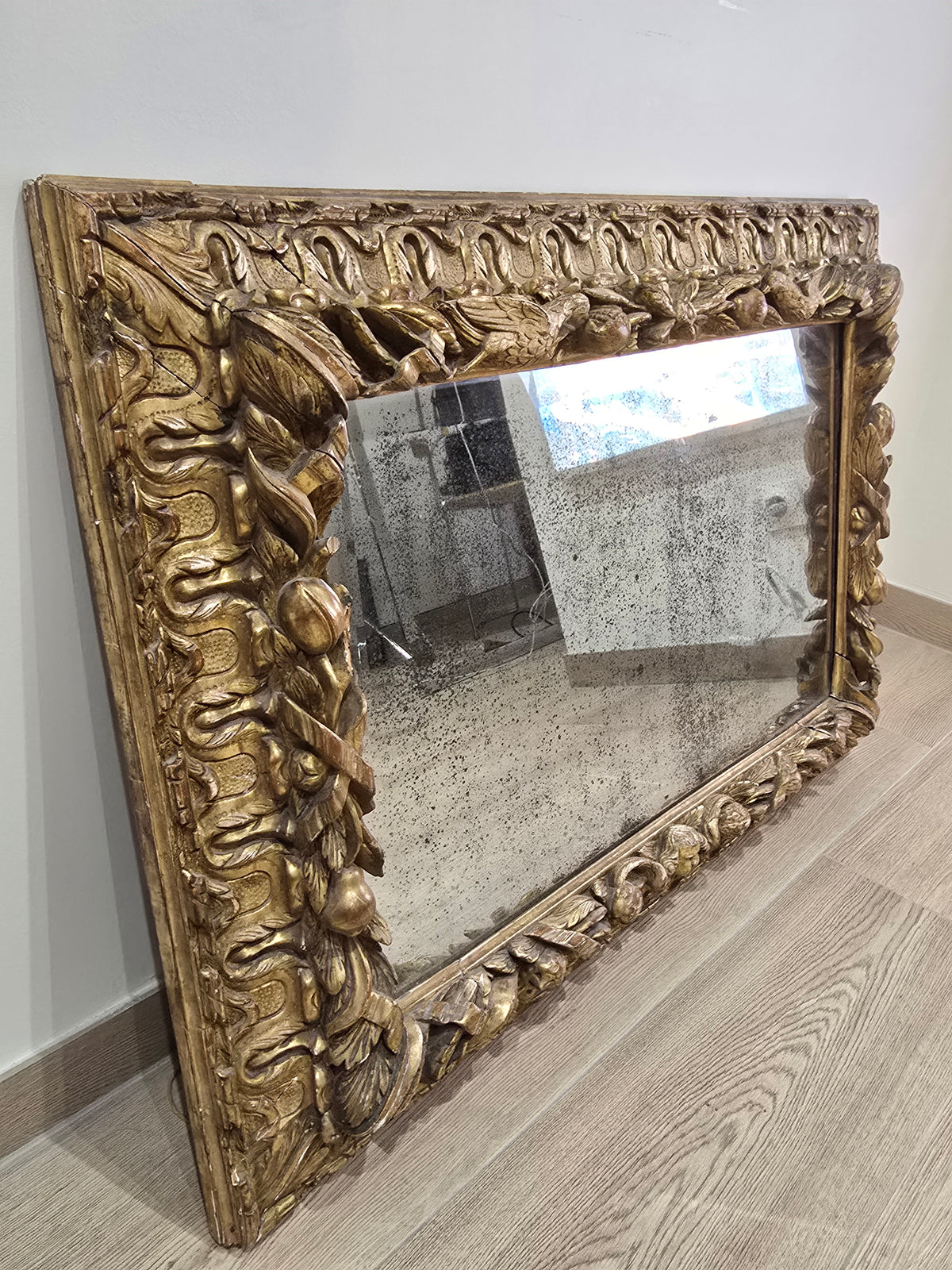 Exceptionnel miroir XVIIIe siècle en bois sculpté doré – décor oiseaux, fruits et angelot – 98 x 68 cm.