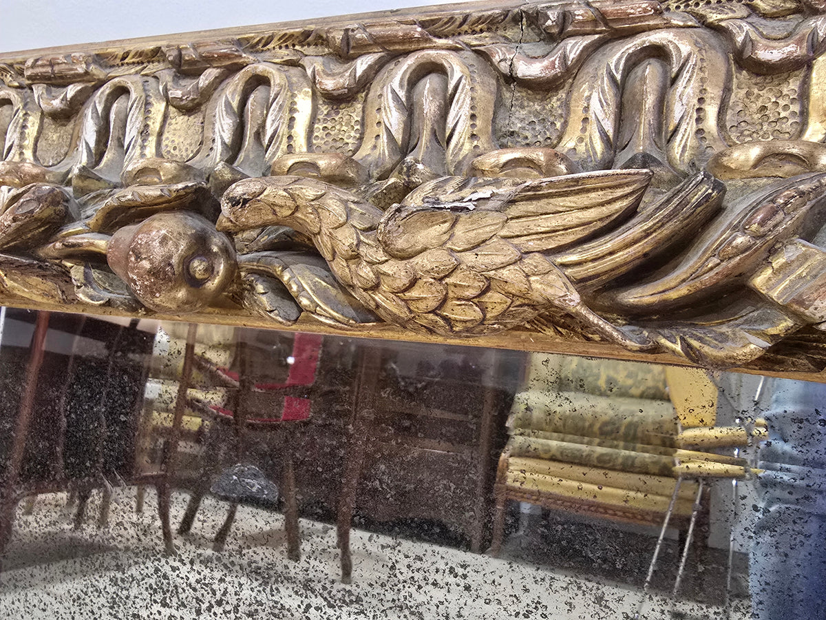 Exceptionnel miroir XVIIIe siècle en bois sculpté doré – décor oiseaux, fruits et angelot – 98 x 68 cm.