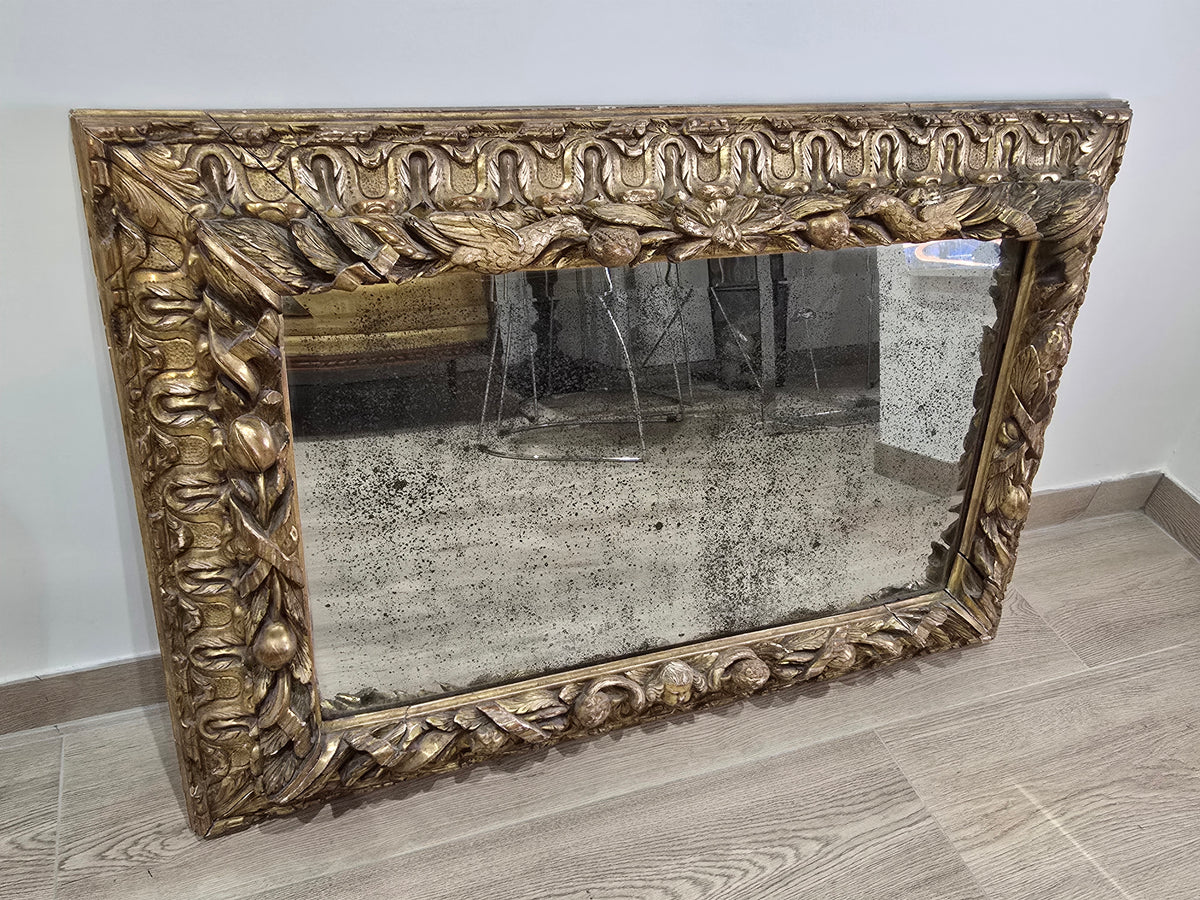Exceptionnel miroir XVIIIe siècle en bois sculpté doré – décor oiseaux, fruits et angelot – 98 x 68 cm.