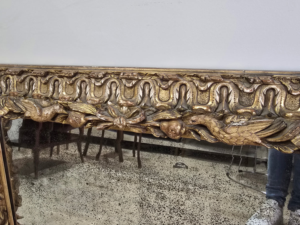 Exceptionnel miroir XVIIIe siècle en bois sculpté doré – décor oiseaux, fruits et angelot – 98 x 68 cm.