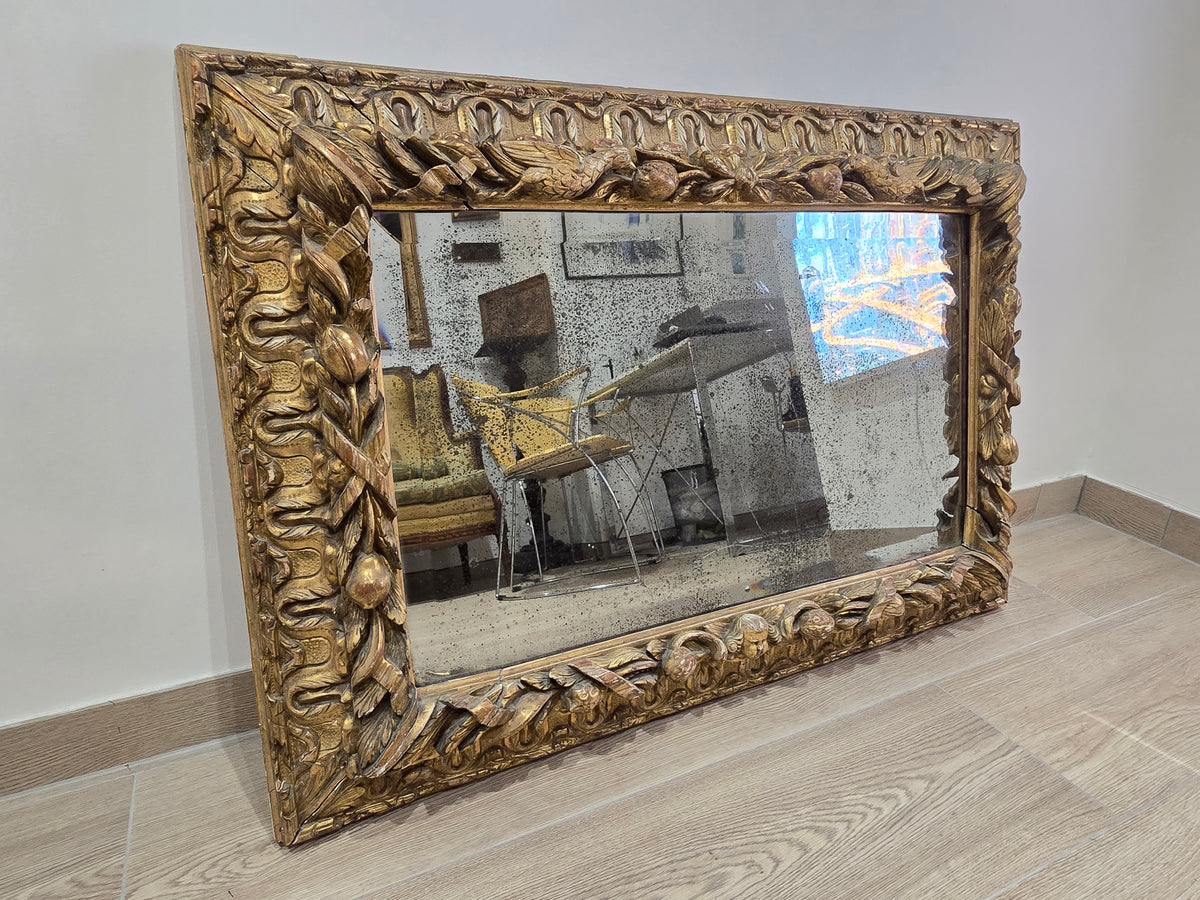 Exceptionnel miroir XVIIIe siècle en bois sculpté doré – décor oiseaux, fruits et angelot – 98 x 68 cm.