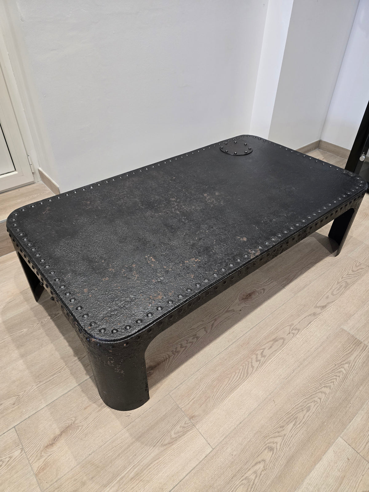 Table basse industrielle en métal riveté vers 1920 – patine noire – 145 × 80 cm