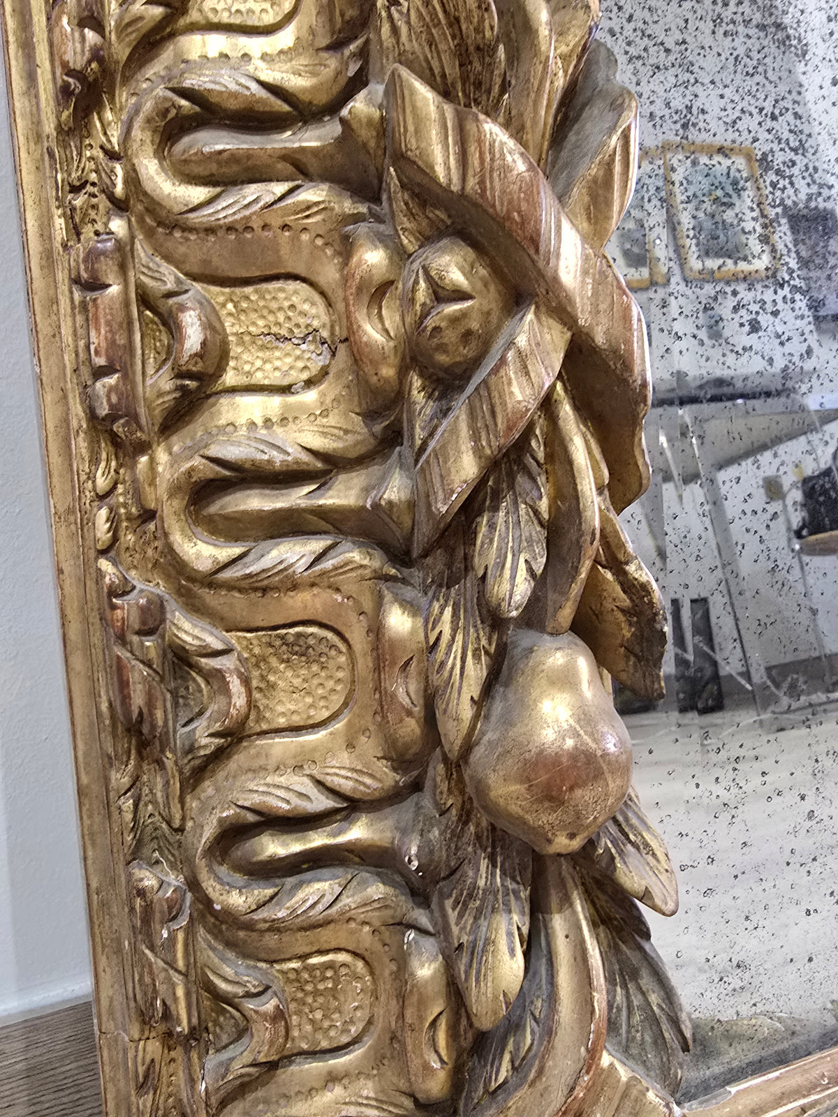 Exceptionnel miroir XVIIIe siècle en bois sculpté doré – décor oiseaux, fruits et angelot – 98 x 68 cm.