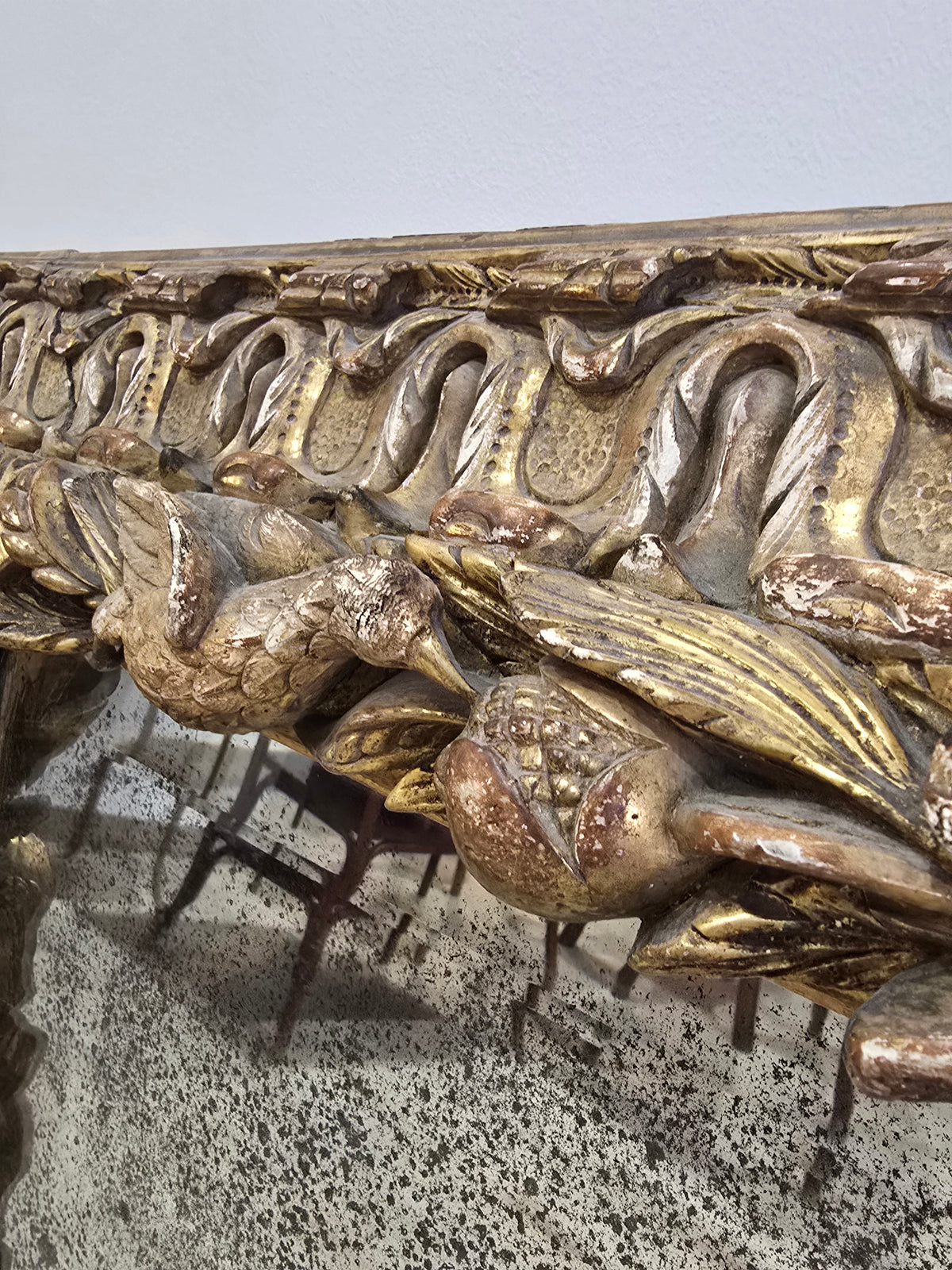 Exceptionnel miroir XVIIIe siècle en bois sculpté doré – décor oiseaux, fruits et angelot – 98 x 68 cm.