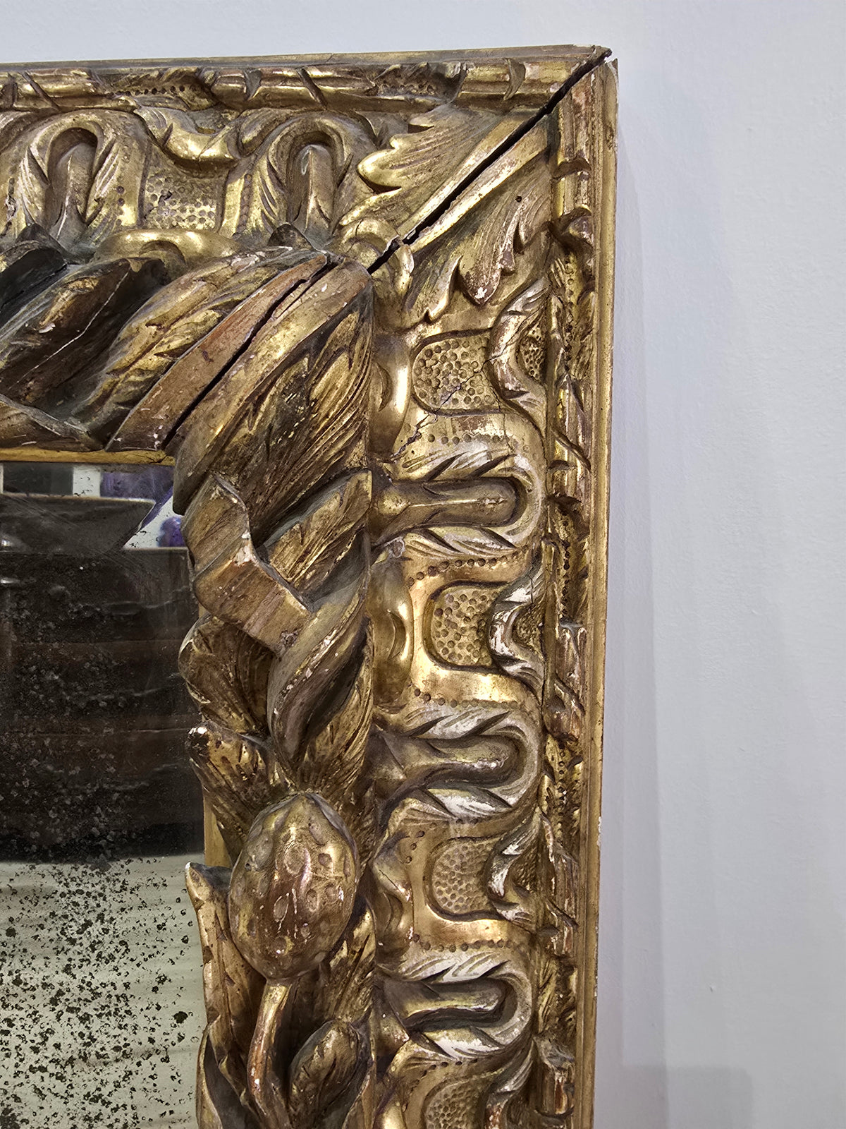 Exceptionnel miroir XVIIIe siècle en bois sculpté doré – décor oiseaux, fruits et angelot – 98 x 68 cm.